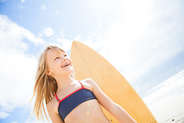 Image showing Happy young girl with surfboard at beach