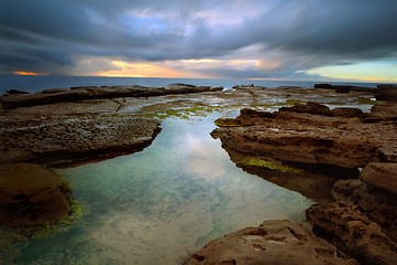 Image showing Stormy sunrise over Little Bay with rockpool in foreground