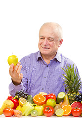 Image showing senior man holding a green apple