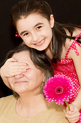 Image showing Little girl surprising grandmother