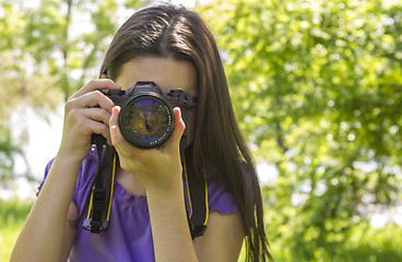 Image showing Young girl taking photos at summer green park