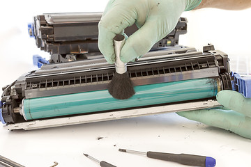 Image showing hands cleaning toner cartridge