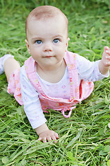 Image showing Happy baby girl lying on grass
