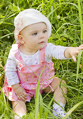 Image showing Curious baby girl on grass