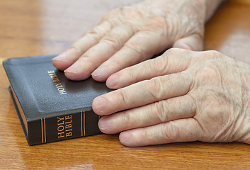 Image showing old man hands on bible