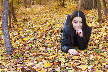 Image showing Teenager laying on leaves