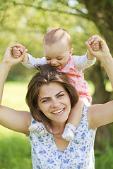 Image showing happy mother with her child on her shoulders