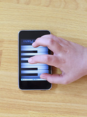 Image showing Playing piano on modern touch screen phone