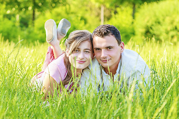 Image showing Young couple lying in park.