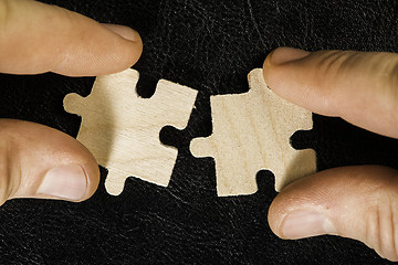 Image showing Wooden puzzle on black background. Close up