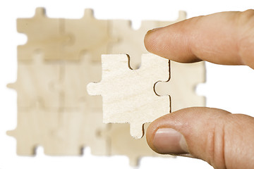 Image showing Wooden puzzle on white background. . Close up