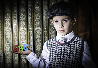 Image showing Child in vintage clothes hold letters a b c
