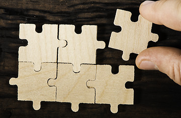 Image showing Wooden puzzle on dark background. 