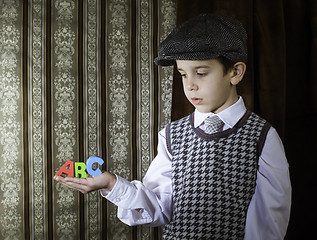 Image showing Child in vintage clothes hold letters a b c