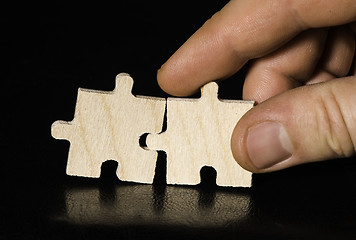 Image showing Wooden puzzle on black background. Close up