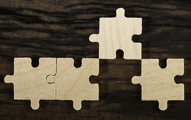 Image showing Wooden puzzle on dark background. 