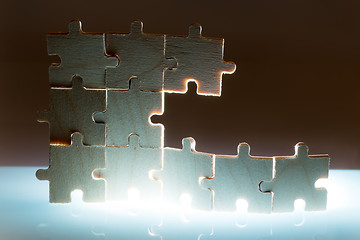 Image showing Wooden puzzle and backlight background. Close up