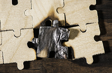 Image showing Burning wooden puzzle on dark background.