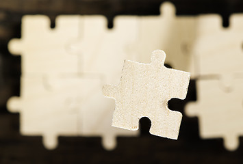 Image showing Wooden puzzle on dark background. 