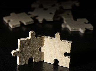 Image showing Wooden puzzle on black background