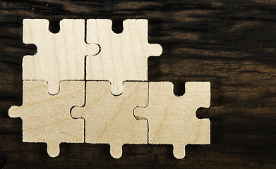 Image showing Wooden puzzle on dark background. 