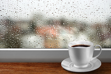 Image showing Coffee cup against window with rainy day view