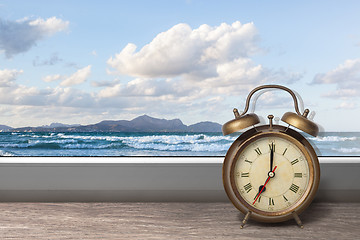 Image showing View of summer sea under blue sky from window with alarm clock