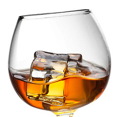 Image showing Splash of whiskey with ice in glass isolated on white background