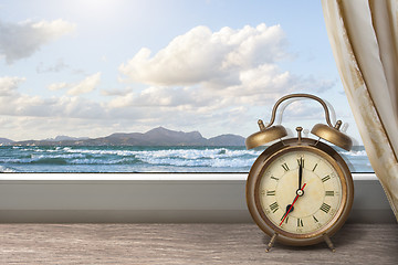 Image showing View of summer sea under blue sky from window with alarm clock