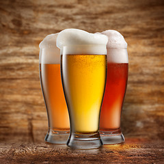 Image showing Different beer in glasses on wooden background