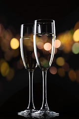 Image showing Champagne in glass on black background with color bokeh