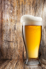 Image showing Glass of beer on wooden background