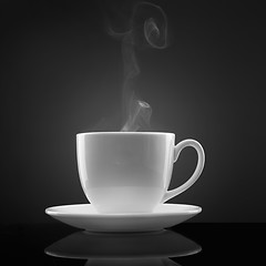 Image showing white cup with hot liquid and steam on black