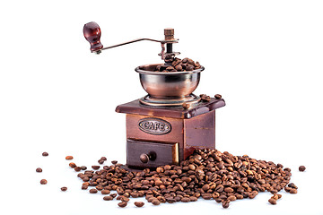 Image showing Retro manual coffee mill on roasted coffee beans isolated