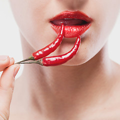 Image showing Young woman with chili pepper isolated on white