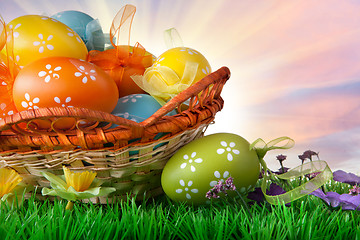 Image showing color easter eggs in basket against sky and clouds