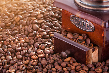 Image showing Retro manual coffee mill on roasted coffee beans