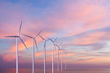 Image showing Wind generators turbines in the sea on sunset