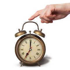 Image showing Brown old style alarm clock with hand isolated on white