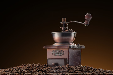 Image showing Retro manual coffee mill on roasted coffee beans