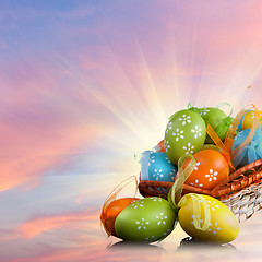 Image showing color easter eggs in basket against sky and clouds