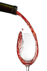 Image showing Red wine pouring into glass with splash isolated on white