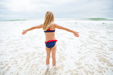 Image showing Young girl standing in water at beach