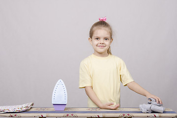 Image showing five year old girl with a smile, stroking lingerie