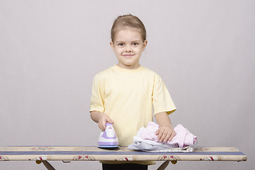 Image showing The child stroking things iron