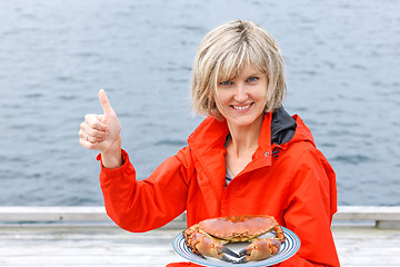 Image showing Happy woman holding cooked crab on white plate