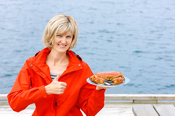 Image showing Happy woman holding cooked crab on white plate