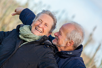 Image showing Elderly couple embracing and celebrating the sun