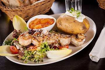 Image showing Grilled prawns with endive salad and jacket potato