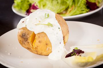 Image showing Baked jacket potato with sour cream sauce